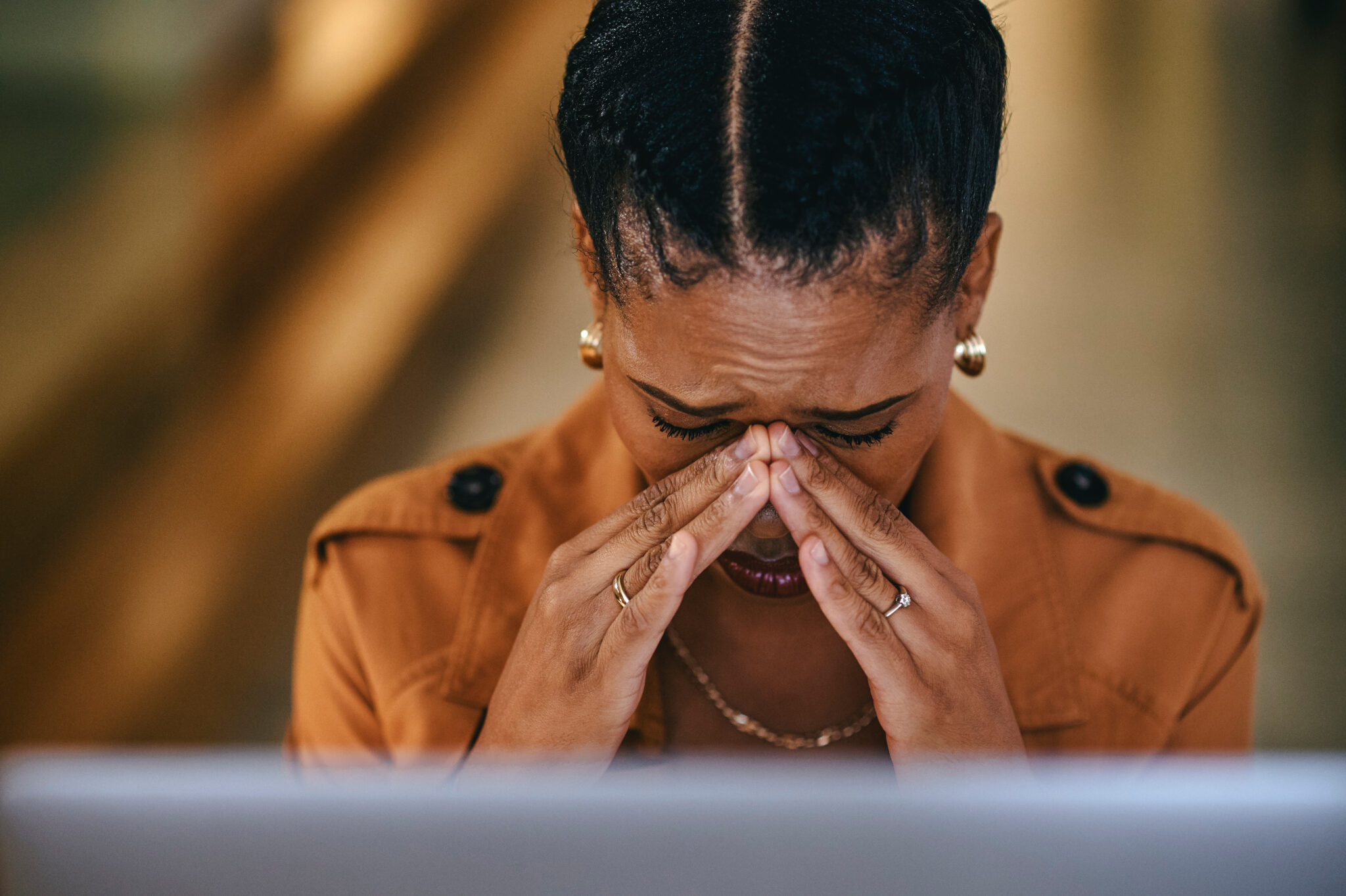 A woman holds her hands up to her face with a pained expression.