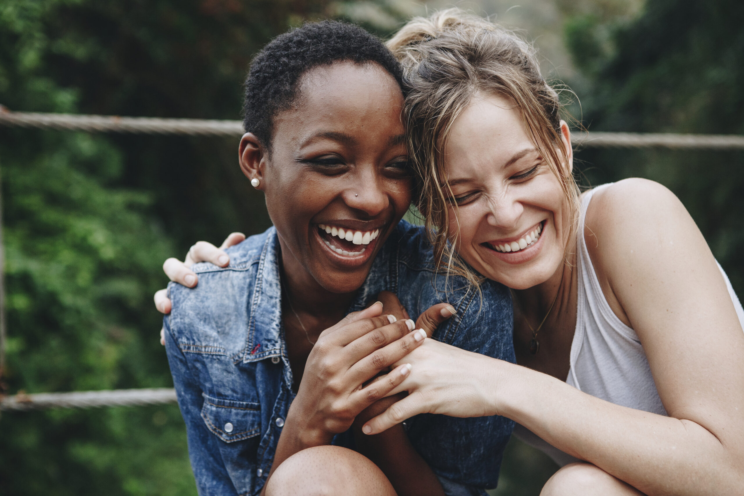 Two friends laughing and hugging.