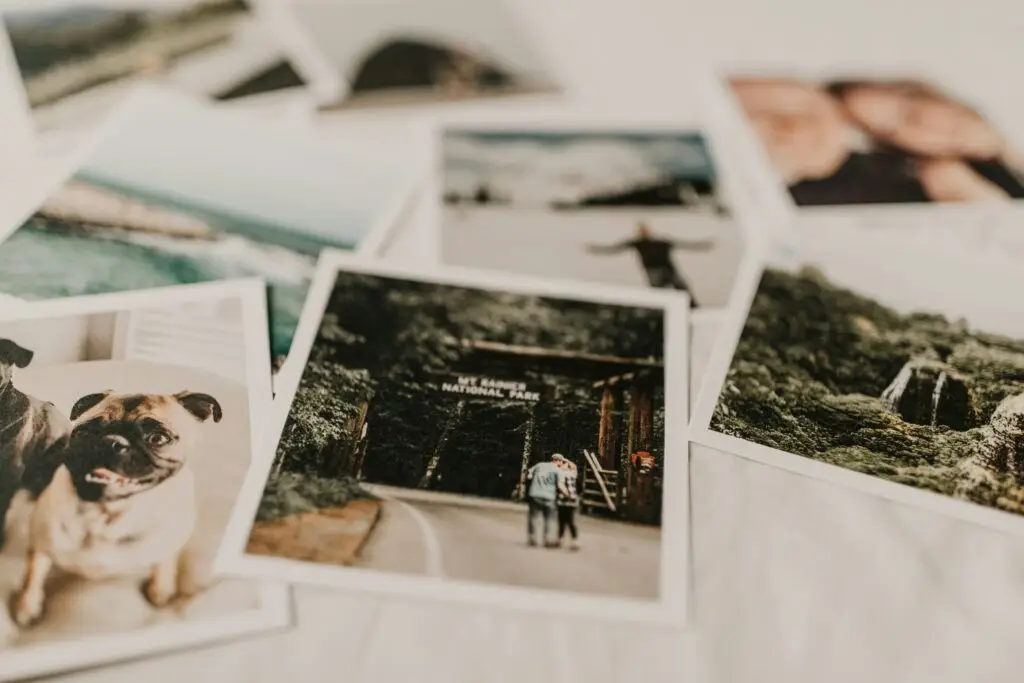 A white table with various old photos scattered across it.