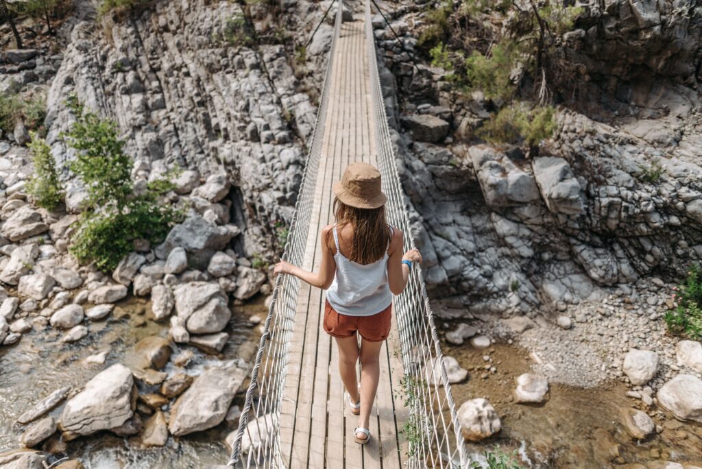 A woman crosses a plank bridge