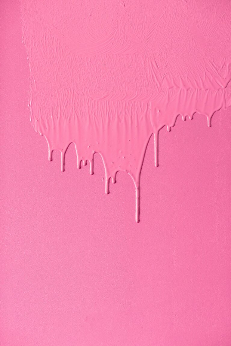 Wet paint drips down a freshly painted pink background